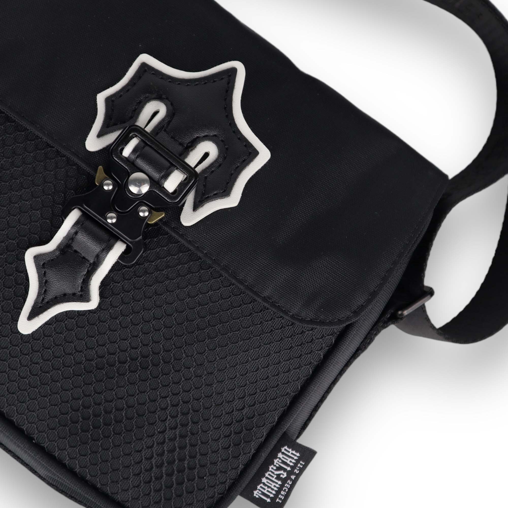 Trapstar black and white Irongate T cross-body bag with adjustable strap and sleek design on a neutral background.