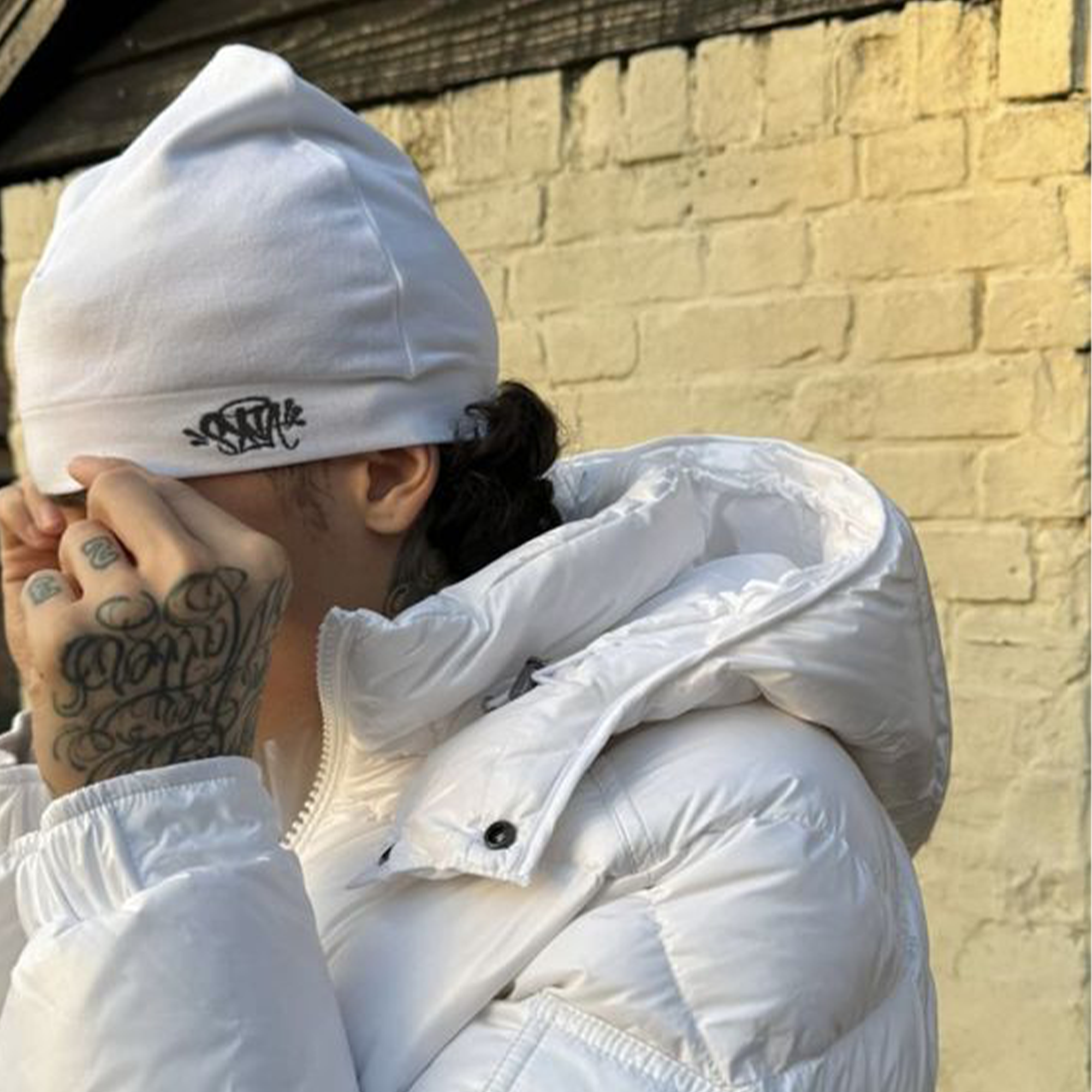 White Syna Skull Cap beanie by Central ae, featuring a snug fit and minimalist design for a stylish look.