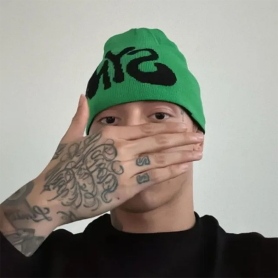 Black and green reversible beanie by Central ae, featuring a stylish two-tone design and a comfortable fit.