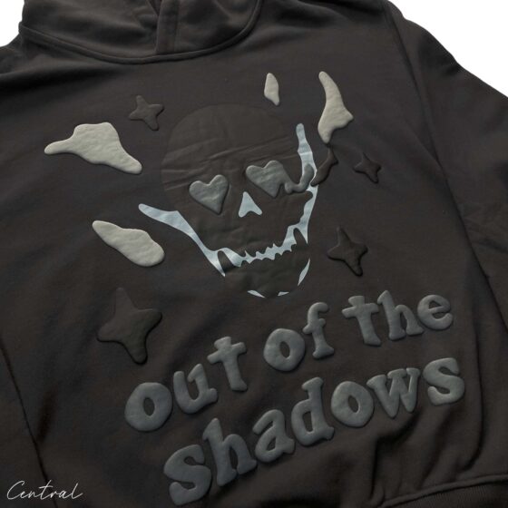 Central ae Broken Planet Out of the Shadows Hoodie in dark fabric with graphic design and adjustable drawstring hood.