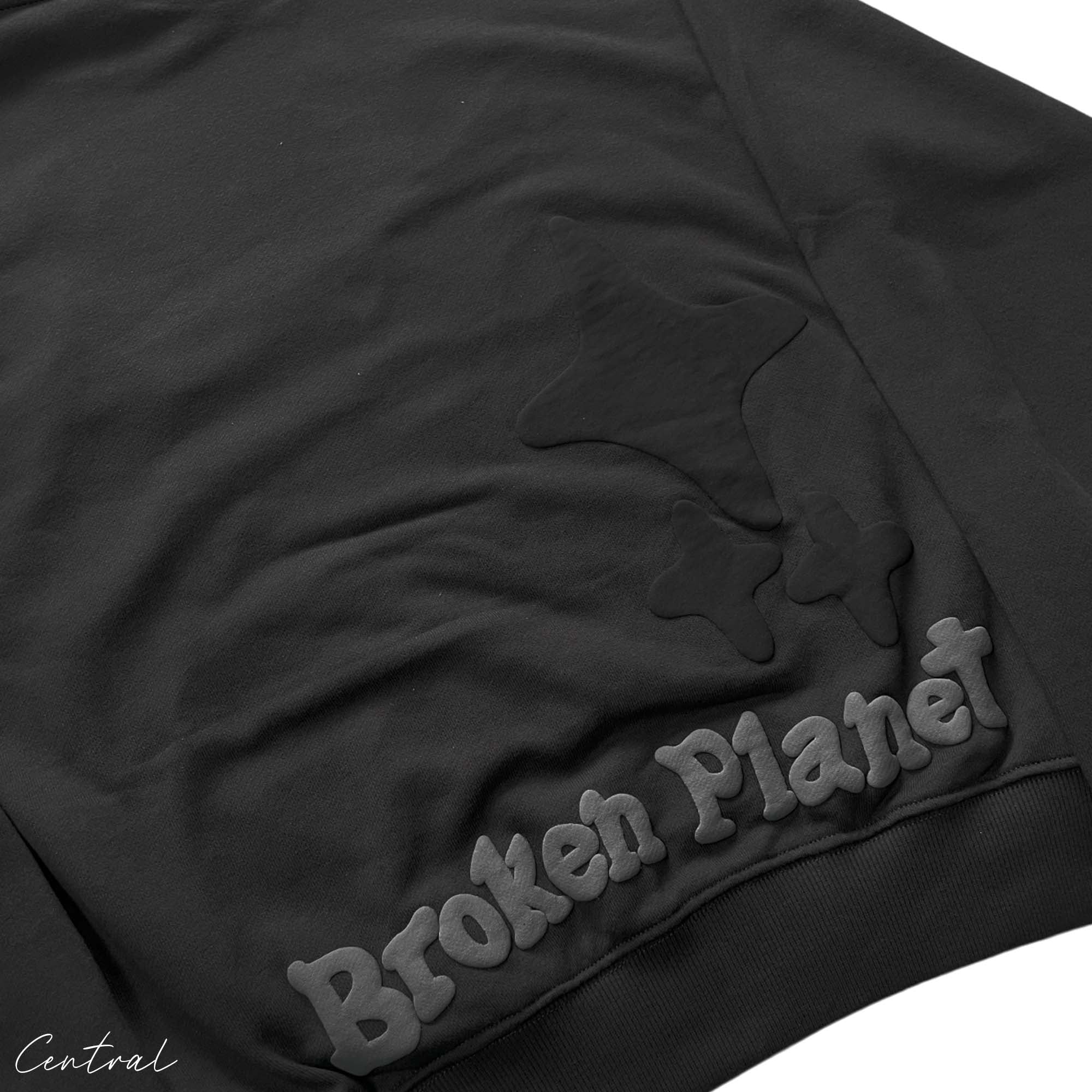 Central ae Broken Planet Out of the Shadows hoodie in black featuring a graphic design on the front.
