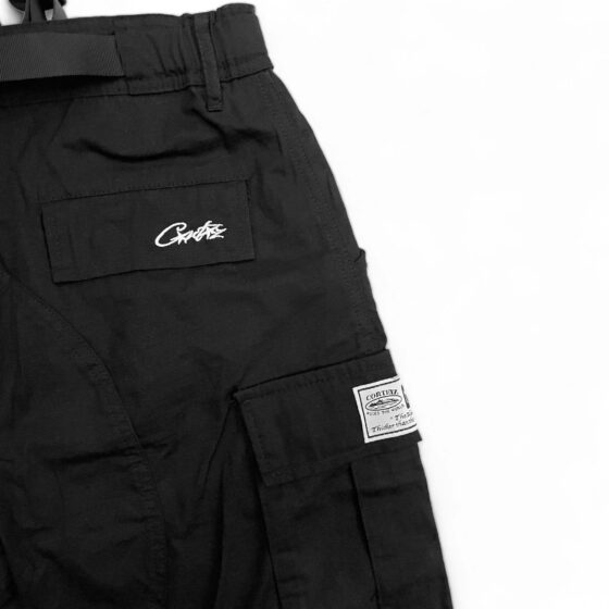 Corteiz cargo pants with multiple pockets, featuring a relaxed fit and durable fabric in a casual outdoor setting.