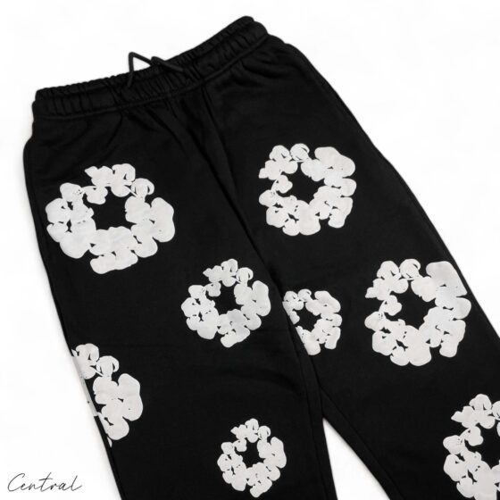 Black sweatpants by Central AE featuring a unique cotton wreath design in denim tears style.