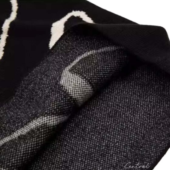Black and cream Rhude knit logo shorts displayed on a neutral background, showcasing the brand's signature style.