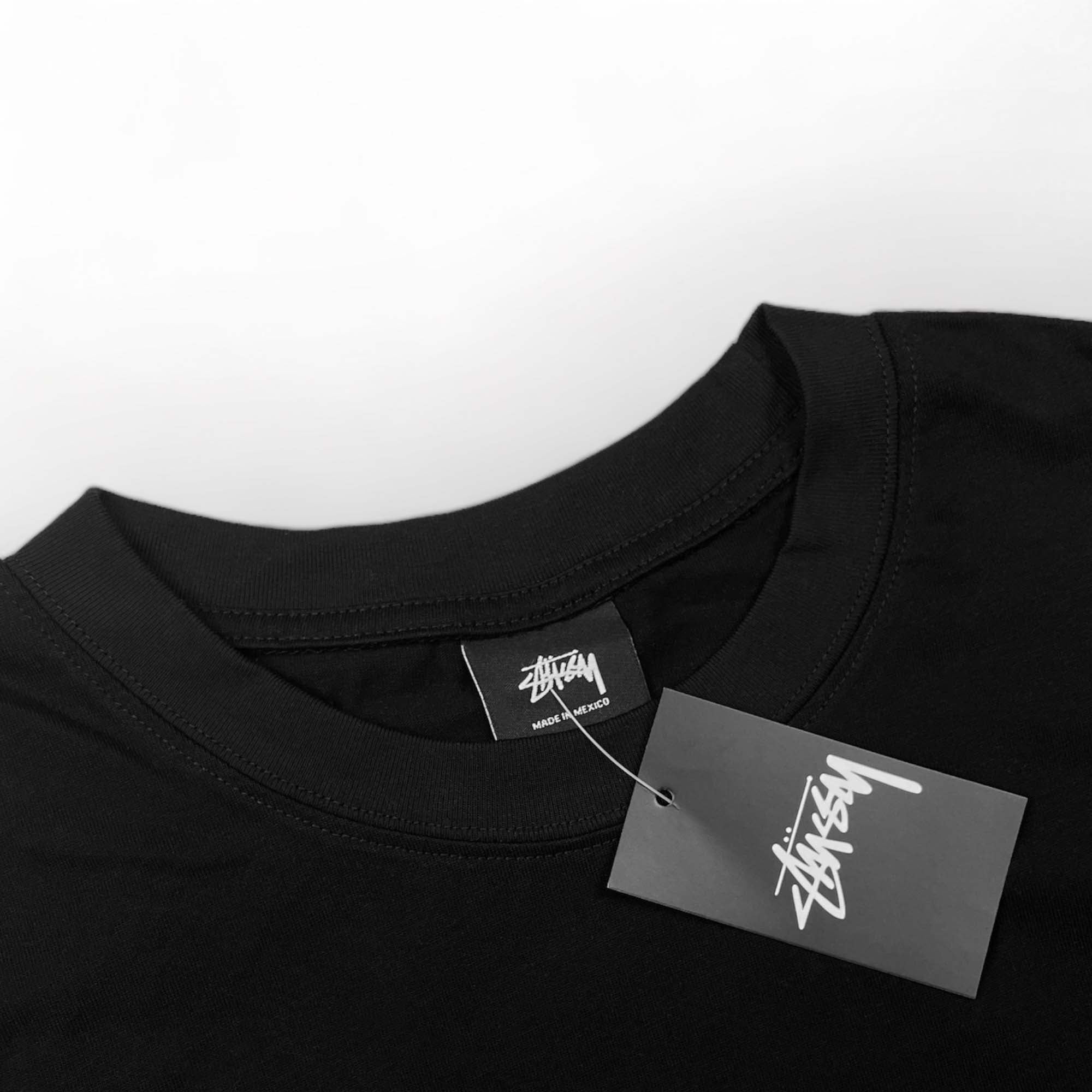 Black BASIC STÜSSY TEE t-shirt featuring a simple design and logo, laid flat on a neutral background.