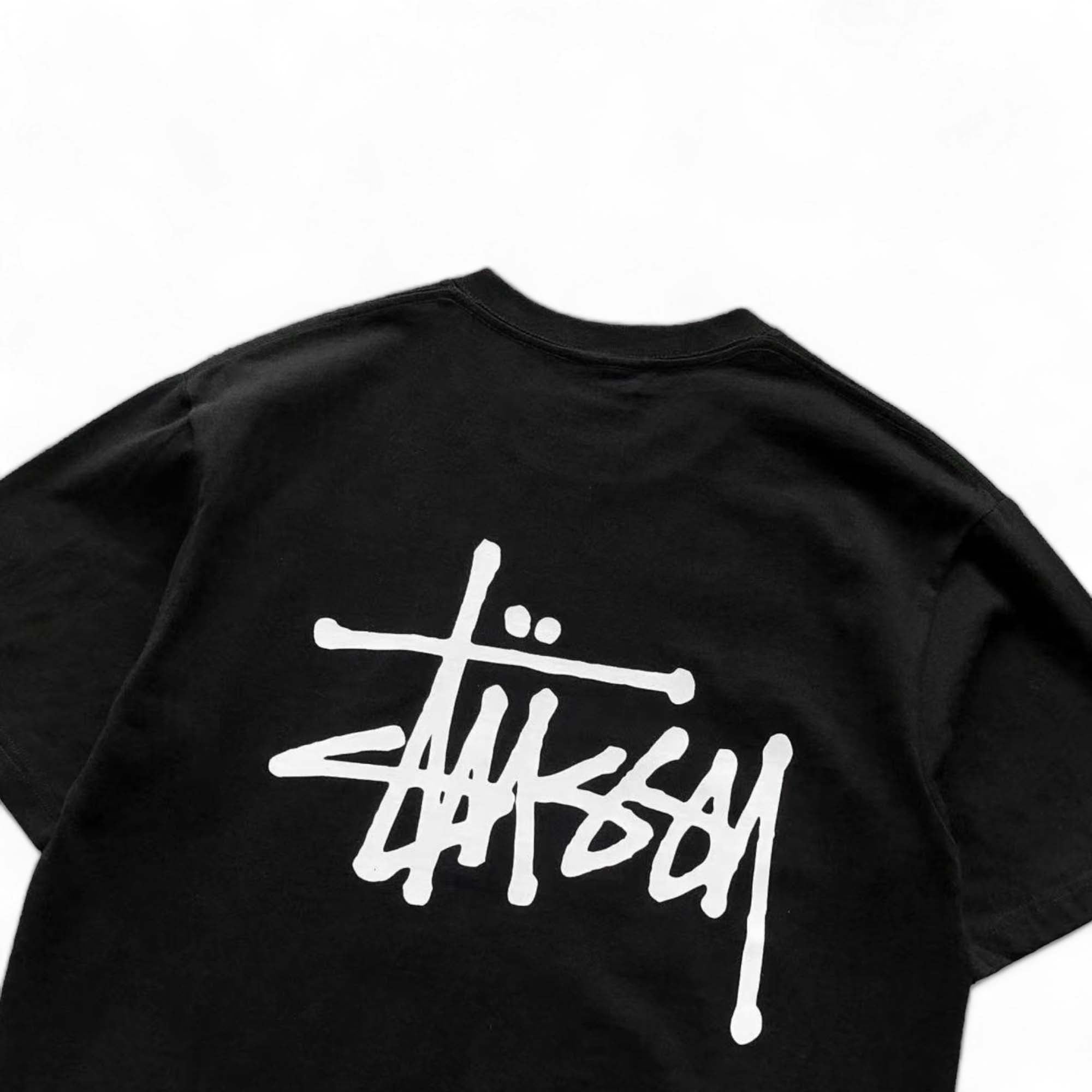 Black BASIC STÜSSY TEE featuring a minimalist design and a comfortable fit, displayed from the back perspective.