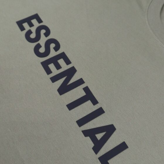 Olive green oversized FOG ESSENTIALS t-shirt laid flat, showcasing its soft fabric and relaxed fit.