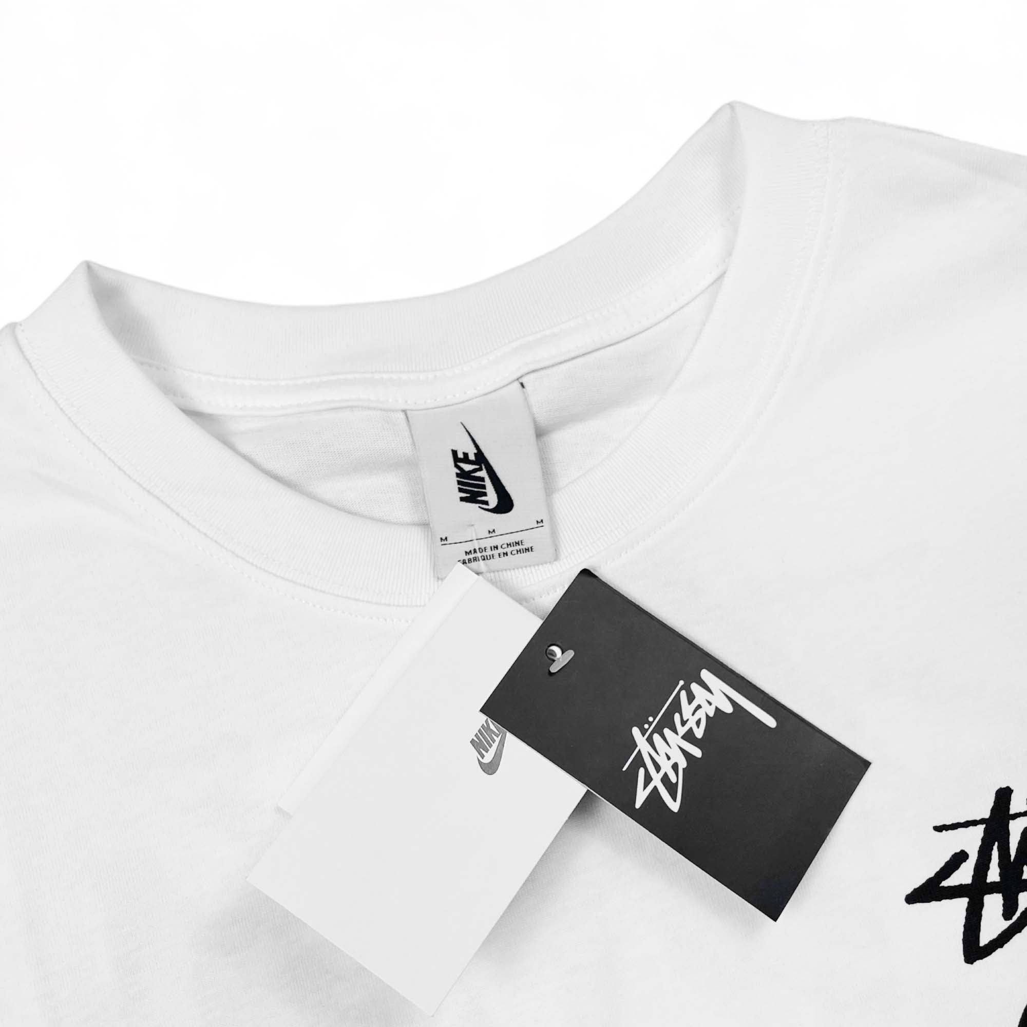 White NIKE X STUSSY 8 Ball T-shirt featuring logo graphics on the front and back, casual fit for everyday wear.