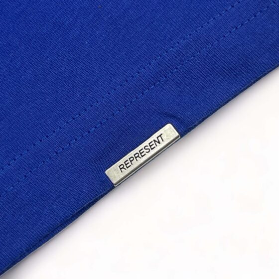 Cobalt blue REPRESENT OWNERS CLUB T-shirt displayed on a flat surface, showcasing front design and fabric texture.