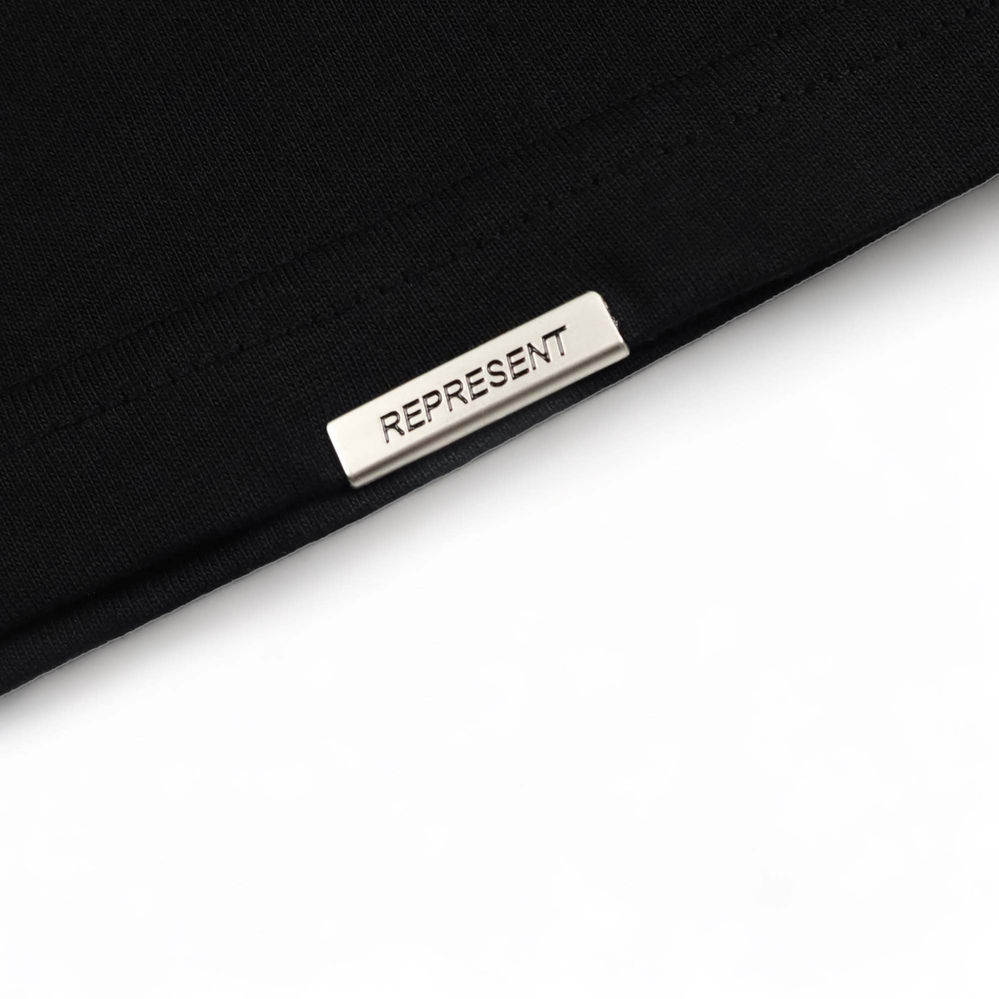 Black Represent 'Your Tute’s Up' t-shirt displayed on a neutral background, showcasing the front design and fabric texture.