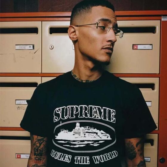 Central AE Sup Corteiz Rules The World Tee featuring bold graphic text on a classic black T-shirt.