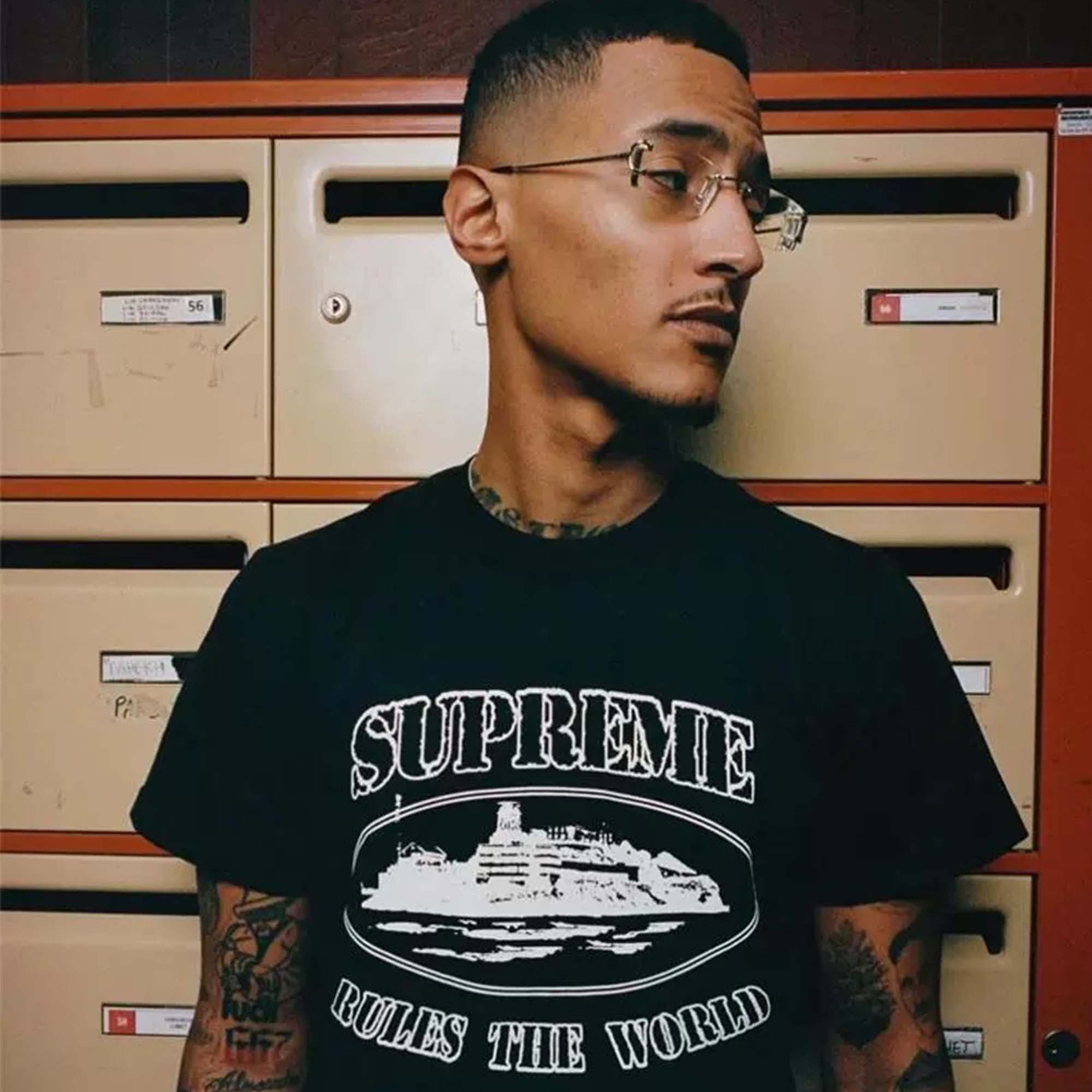Central AE Sup Corteiz Rules The World Tee featuring bold graphic text on a classic black T-shirt.