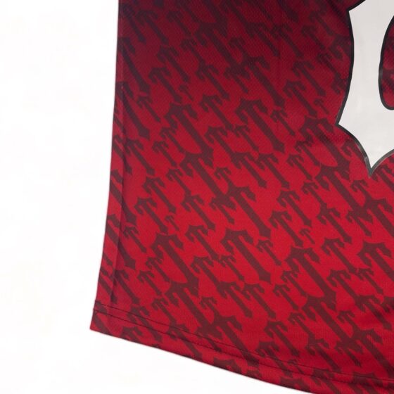Red gradient Trapstar monogram jersey t-shirt featuring bold logo design on soft fabric.