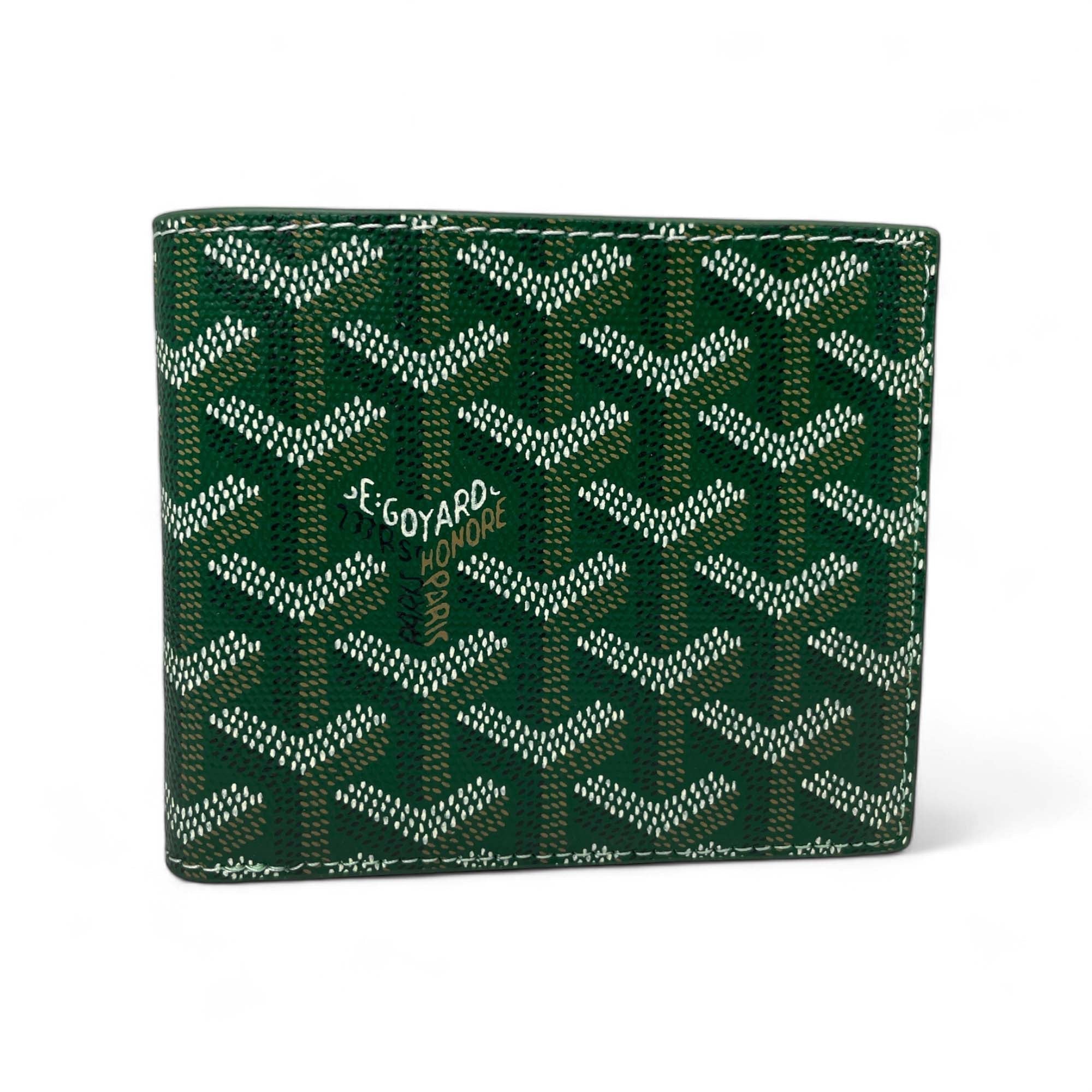 Green Goyard wallet by Central ae, featuring a sleek design and iconic logo pattern on premium material.