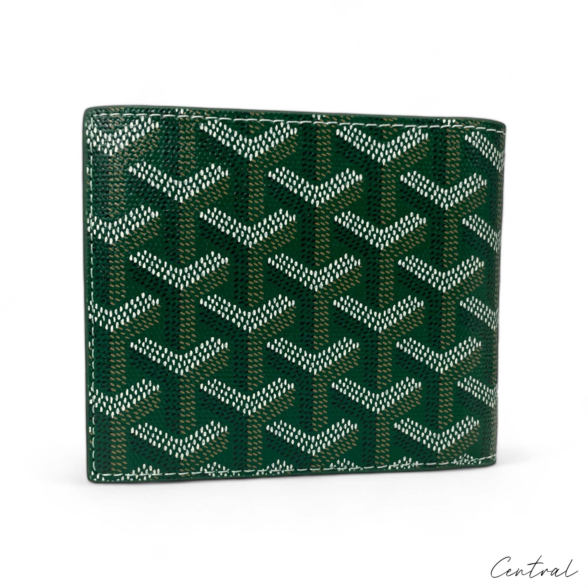 Green Goyard wallet by Central ae, featuring a sleek design with the brand's signature pattern and logo.