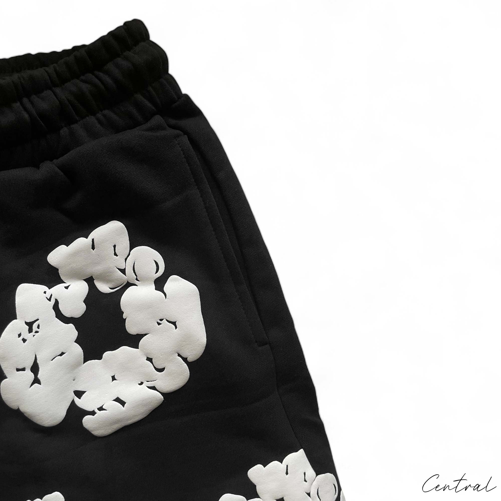 Black Denim Tears Cotton Wreath Shorts displayed on a neutral background, showcasing unique design and texture.